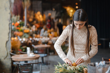 A radiant young woman fully immersed in a Christmas decor DIY workshop.