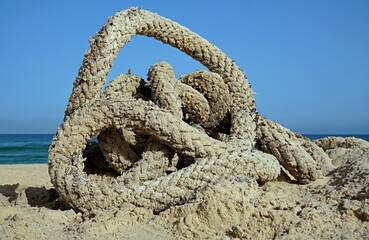 Old ship rope on the sand near the seashore