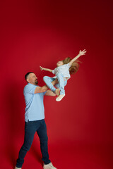 Flying High with Dad. Father tosses his daughter playfully into air, capturing moment of carefree...