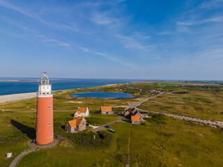 An aerial perspective showcases a majestic lighthouse standing tall near the sandy shores,...