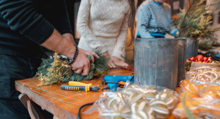 A young lady making a Christmas wreath at a DIY decor session.