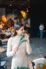 A young woman crafting a festive wreath during a decor-making seminar.