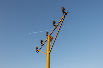 Tall electrical power pole against a vibrant blue sky
