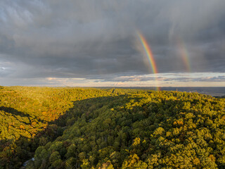 Faint sunset rainbow over Coopers Rock State Forest with fall foliage