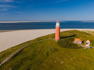 A breathtaking aerial view capturing the towering lighthouse standing tall on the sandy shores of...