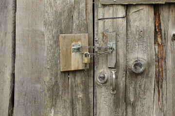 Old wooden doors in a barn with a small lock on a chain