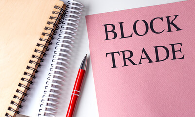 BLOCK TRADE text on pink paper with notebooks