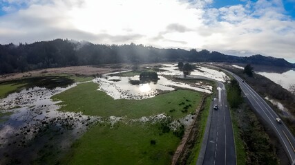 aerial view of flood water flowing into the road with an almost empty road below