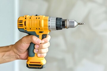 Hand Holding Yellow Cordless Power Drill
