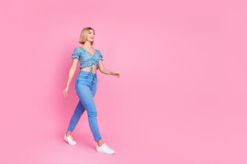 Full size photo of pretty young girl walk empty space wear top isolated on pink color background
