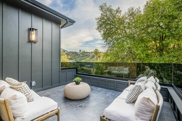 two white couches sitting on top of a tiled patio