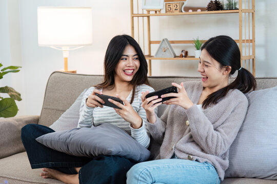 Happy woman lesbian gay lgbt couple enjoying fun gaming session on the couch at home. lgbt concept