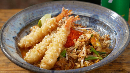Closeup of a bowl of Shrimp Pad on a wooden table