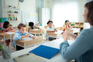 Teacher and students, Learn and study in a classroom of school where youngsters sit and listen attentively.
