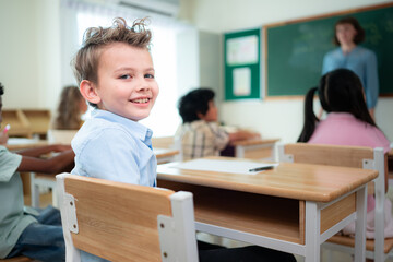 Teacher and students, Learn and study in a classroom of school where youngsters sit and listen attentively.