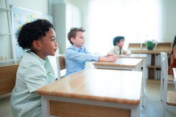 Students learn and study in a classroom of school where youngsters sit and listen attentively.