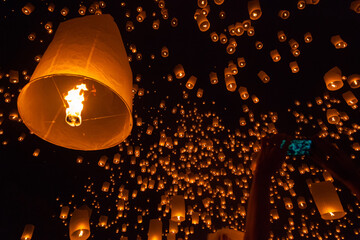 Enchanting night sky filled with floating lanterns during the Chiang Mai Lantern Festival in Thailand. © Chen