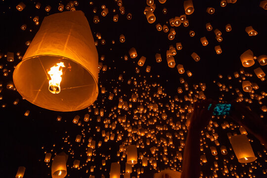 Enchanting night sky filled with floating lanterns during the Chiang Mai Lantern Festival in Thailand.