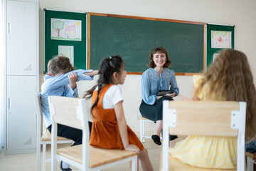 Teacher and students, Learn and study in a classroom of school where youngsters sit and listen attentively.