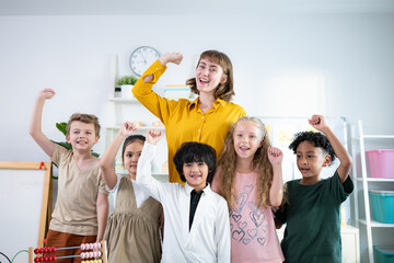 Portrait of a teacher and kids in a classroom where children have pleasure learning.