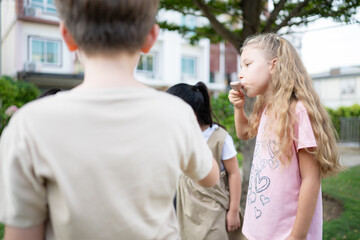 Schoolchildren participating in outdoor activities and relaxing with eating ice cream.