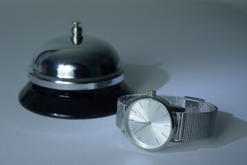 Classic bell for the visitor at the reception and a wristwatch. Retro hotel concept