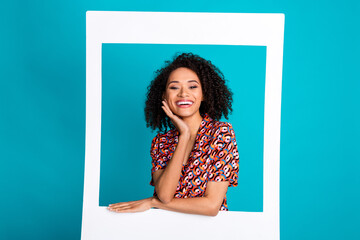 Photo of attractive girl in photo frame smiling isolated cyan color background