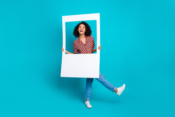 Photo of positive cheerful girl hold photo frame moving isolated cyan color background