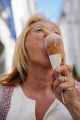 a mature woman eating a ice cream in summer holidays