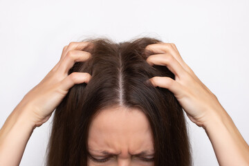 Cropped shot of a young woman scratching her head with her fingers, isolated on a white background....