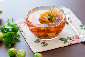 vegetable soup with Brussels sprouts and cauliflower, in a glass plate on a wooden table