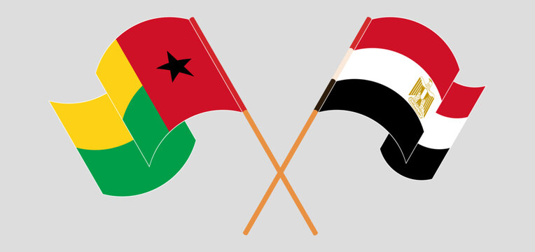 Crossed and waving flags of Guinea-Bissau and Egypt
