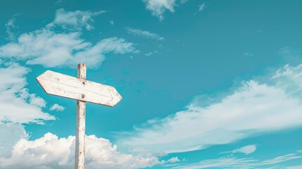 Blank wooden signpost against blue sky