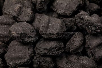 Closeup of charcoal briquettes. Barbecue grill cooking, grilling safety and manufacturing concept.