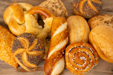 wicker basket overflowing with freshly baked pastries: cheese and poppy seed buns, pretzels, and sweet curd tarts