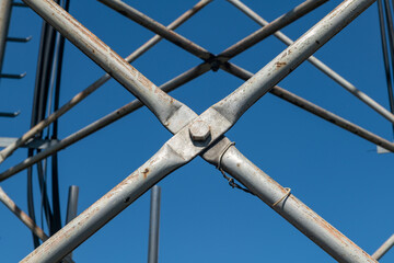 Steel pylon details, reticular structure of a repeater antenna for radio, telephone and communications bands. Stainless steel tie rods and nuts.