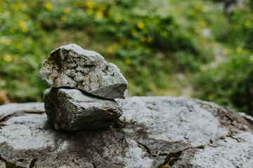 Two stones one in on top of the other on a natural background.