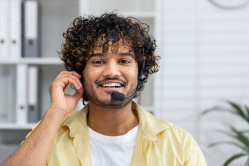 Smiling customer service representative wearing a headset in a modern office, ready to assist...