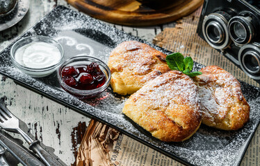 Delicious pastry buns with cottage cheese, sour cream, berries jam on rustic background. Sweets,...