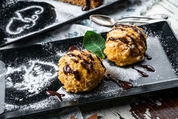 Crispy cakes with cream and chocolate on wooden background. Sweets, dessert and pastry, top view