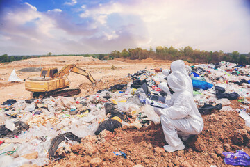 Scientists with protective suit, investigated and inspected garbage pile in landfill. An...