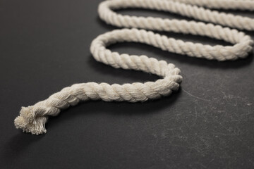 beige rope on dark background close up