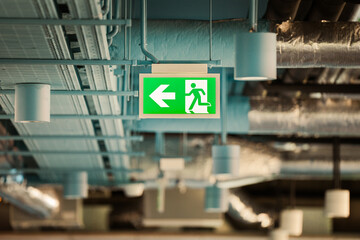 Emergency exit sign. Office spaces. Industrial ceiling