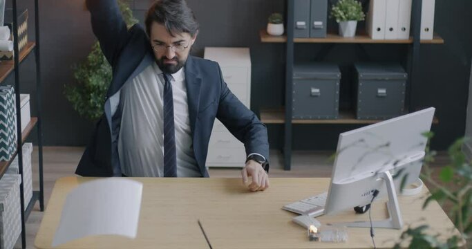 Loop of crazy employee in suit throwing things and documents from computer table feeling angry and annoyed in office. Emotion and business concept.