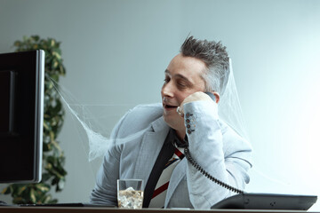 Man covered in cobwebs, talking on phone