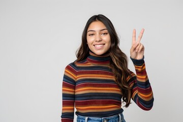 Smiling Young Woman Giving Peace Sign in Striped Top. Casual and Friendly. Perfect for Lifestyle Blogs. Studio Portrait. Generative AI