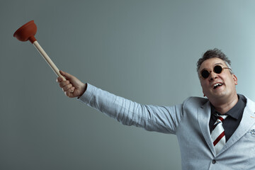 Man in sunglasses raises plunger happily