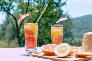Summer refreshing lemonade drink with grapefruit, lemon and orange slices. Fresh healthy cold citrus beverage. Citrus fruit infused water.