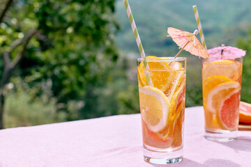 Summer refreshing lemonade drink with grapefruit, lemon and orange slices. Fresh healthy cold citrus beverage. Citrus fruit infused water.