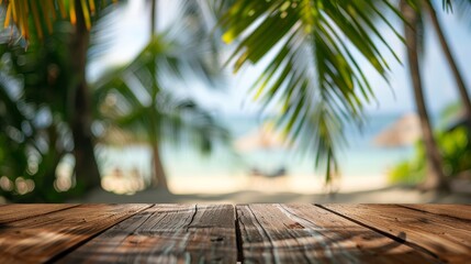 Empty wooden table top for product display, presentation stage. Tropical summer, palm trees, beach bar, white sand and blue ocean in the background. 